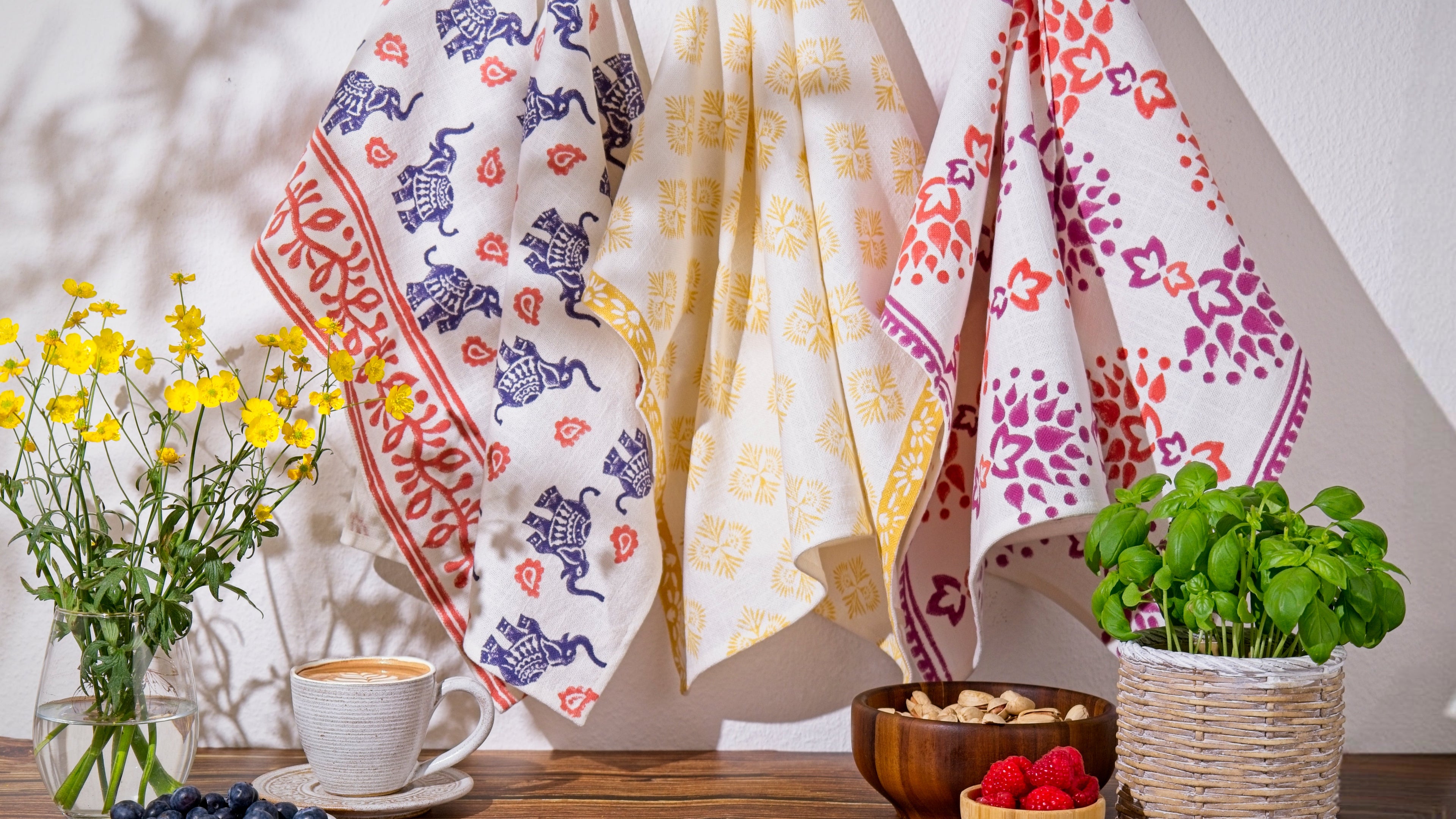 Colorful hand printed tea towels hanging in kitchen